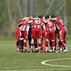 A group of soccer players in a huddle