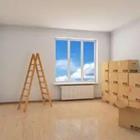 A room with a window and a ladder and boxes everywhere